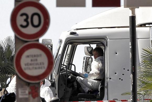 Policiais investigam a cabine do motorista do caminhão que se jogou sobre uma multidão em Nice, na França