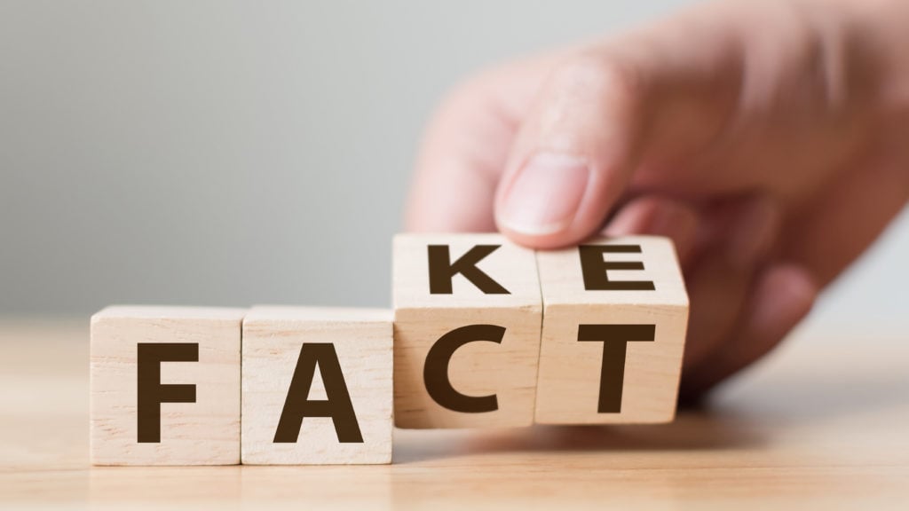 Fact or Fake concept, Hand flip wood cube change the word, April fools day