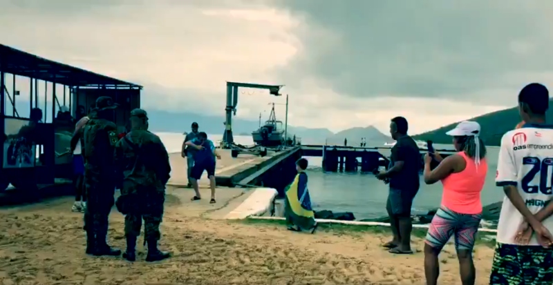 Zona militar: ao avistar criança enrolada com a bandeira nacional, Bolsonaro repete o gesto que simula arma com as mãos[fotografo]Reprodução[/fotografo]