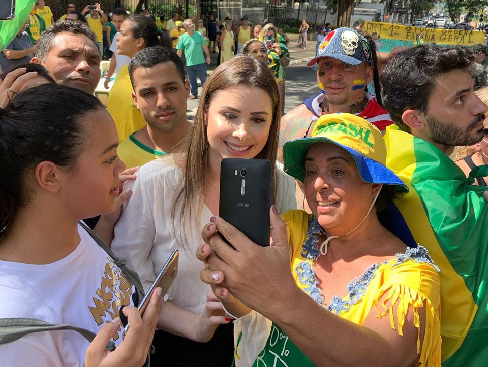 Deputada Caroline Tadeu tira foto com apoiadores que participavam da manifestação pró-governo, no último domingo (15). O Ministério da Saúde recomendou na última sexta-feira (15) evitar aglomerações devido ao novo coronavírus.