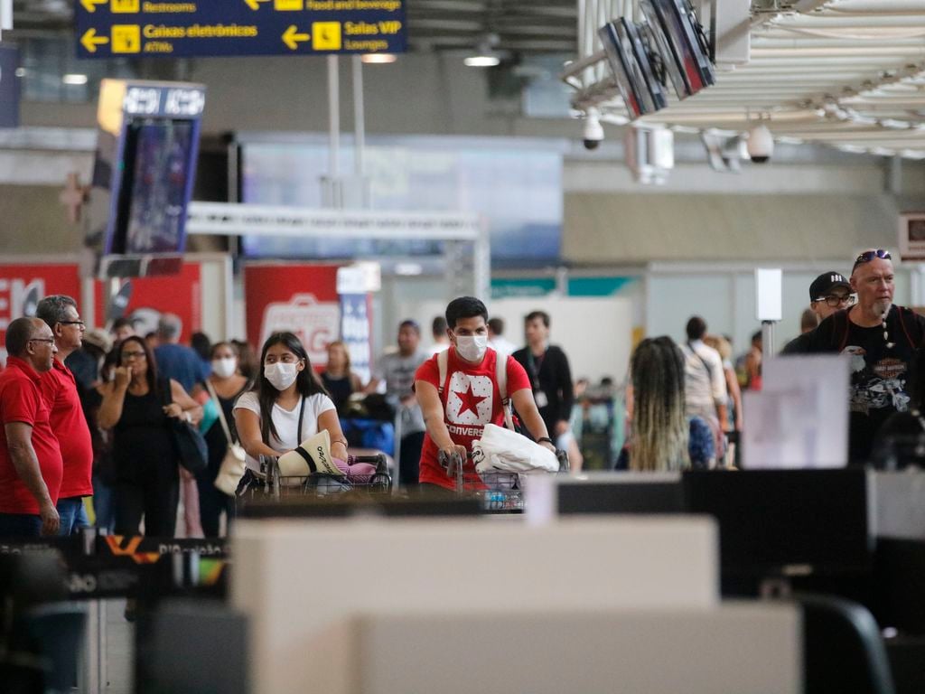 Passageiros e funcionários circulam vestindo máscaras contra o novo coronavírus (Covid-19) no Aeroporto Internacional Tom Jobim- Rio Galeão