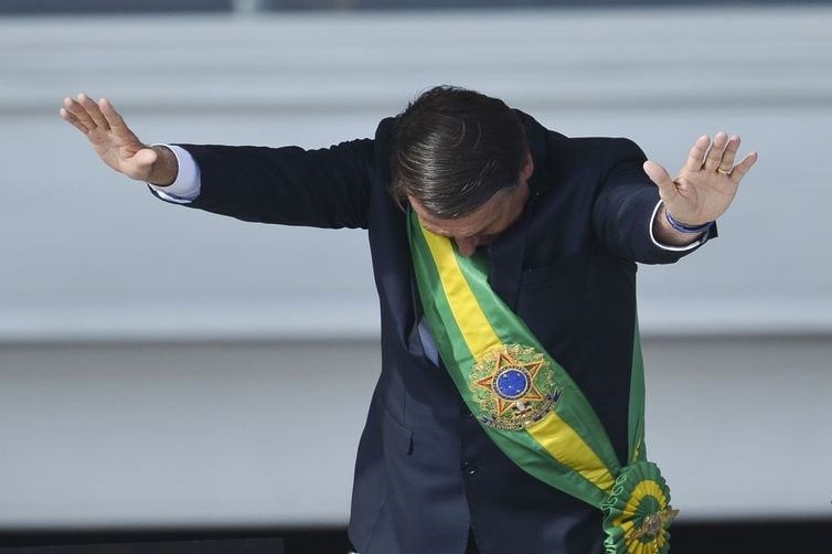 Presidente Jair Bolsonaro saúda o público durante posse presidencial, no Palácio do Planalto. Foto: Reprodução [Marcelo Camargo/Agência Brasil]