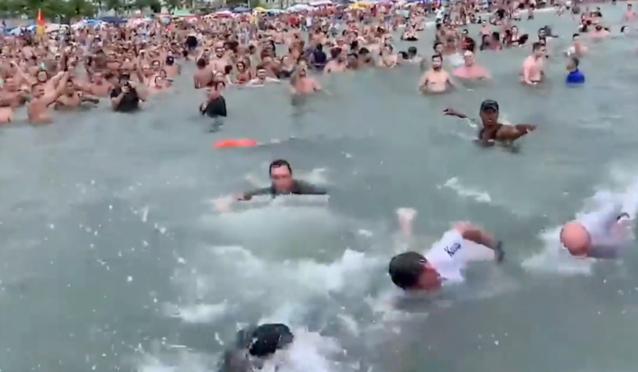 Bolsonaro, de camiseta branca, nada entre apoiadores na Praia Grande, no litoral paulista