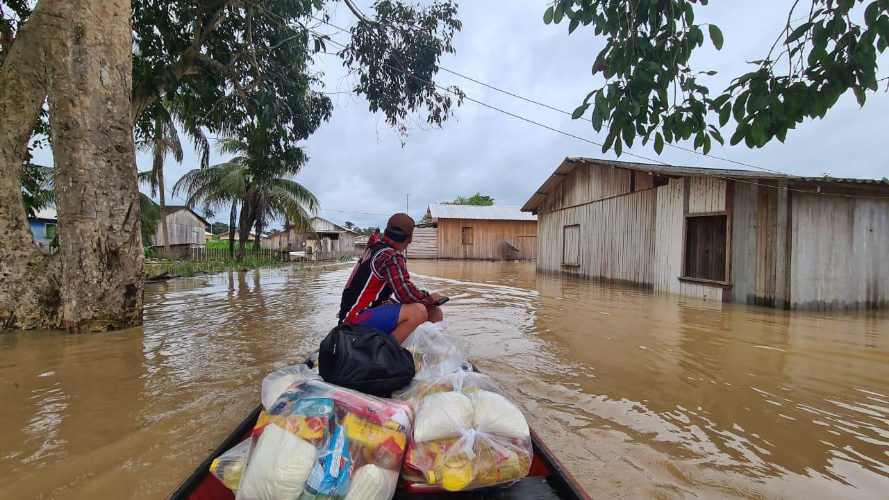 Com ruas alagadas, moradores usam barcos para levar cestas básicas [fotografo]Juan Diaz[/fotografo]