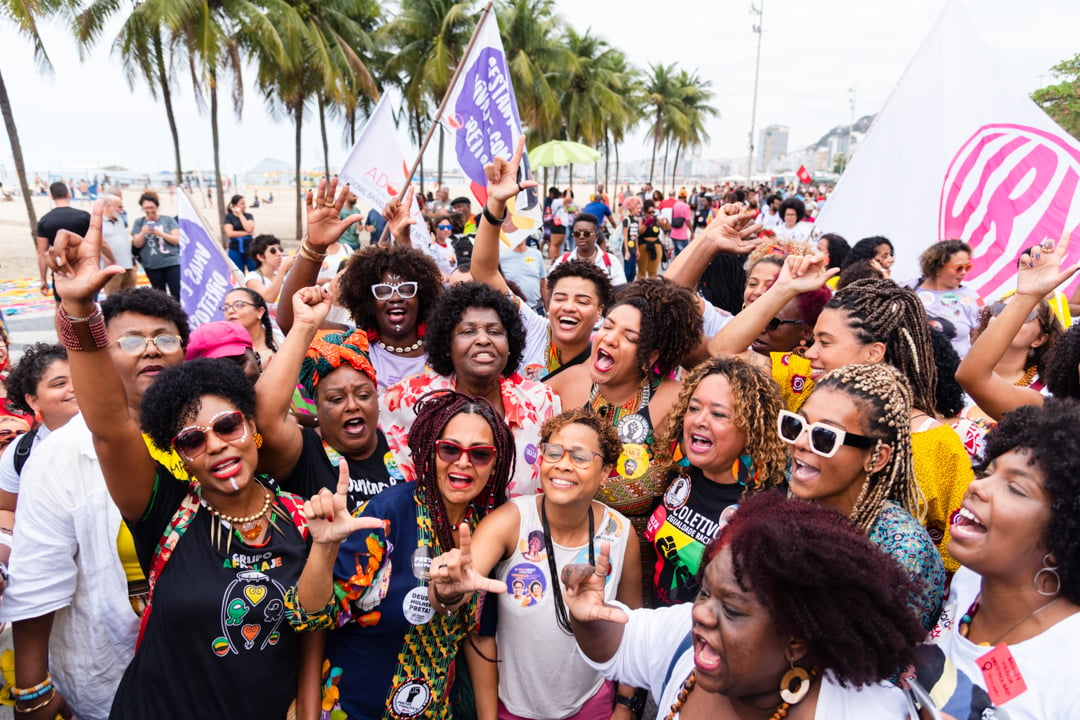 Mulheres negras cantam juntas na VIII Marcha das Mulheres Negras em Copacabana. Da esquerda para a direita estão as Deputadas Estaduais e Federais Monica Francisco, Benedita da Silva, Renata Souza, Verônica Lima, Talíria Petroni, Dani Balbi. Foto: Divulgação