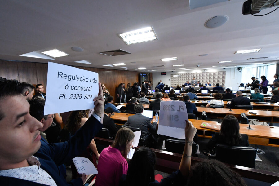 Sessão da comissão temporária que analisa a regulação da inteligência artificial. Na foto, manifestante segura um cartaz ao apoio ao projeto. Foto: Edilson Rodrigues/Agência Senado