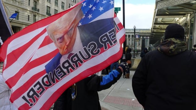 Apoiador de Trump segura uma bandeira com o rosto do presidente. Foto: Luciana Bauer