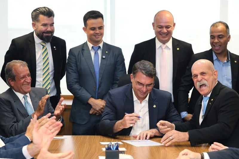 Flávio Bolsonaro abona a ficha de filiação ao PL do deputado Sargento Farhur, à direita.