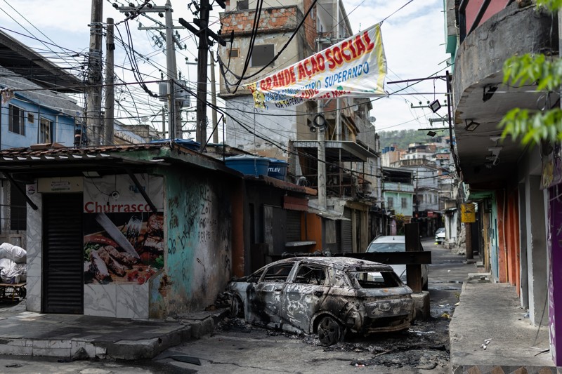 Veículo incendiado durante confronto entre policiais e traficantes na Vila Cruzeiro, no Rio, em outubro de 2025, na operação policial mais letal da história do país.