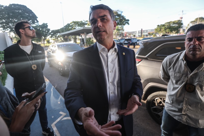 Flávio Bolsonaro fala com jornalistas durante entrevista coletiva em frente ao aeroporto de Brasília na última sexta-feira (15).