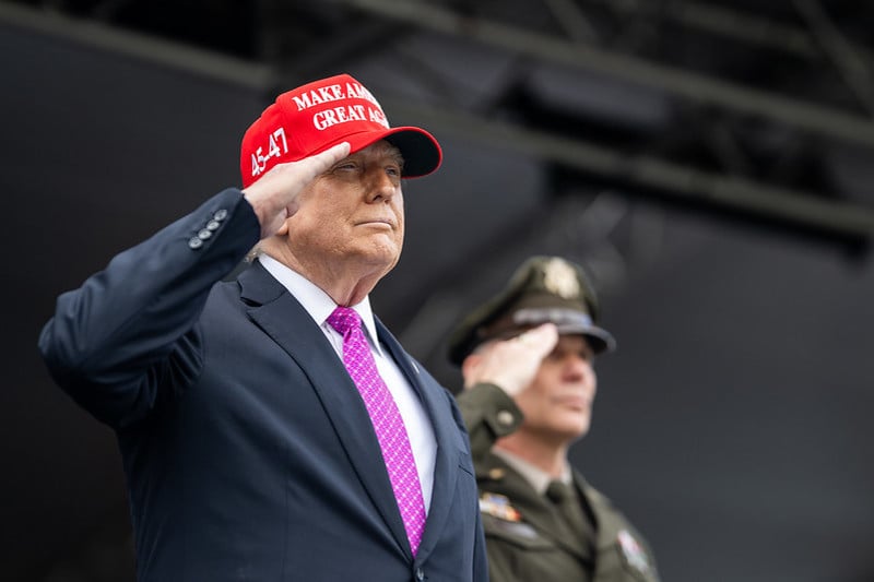 Trump e o boné com seu lema eleitoral: 
