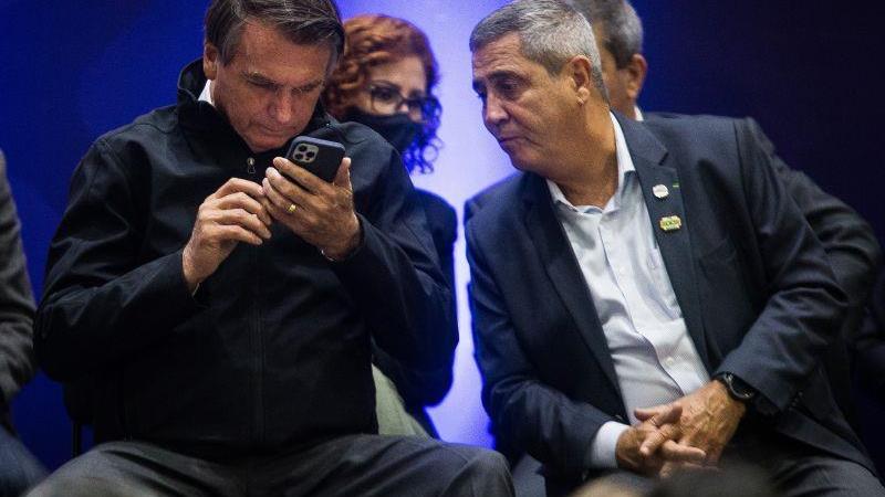 Menções ao ex-presidente dominaram a rede social X durante a manhã. Na foto, Bolsonaro observa celular cercado de aliados, em 2021.