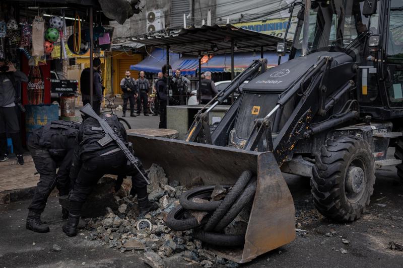 Policiais retiram barricada durante operação no Complexo da Maré, na zona norte do Rio de Janeiro.