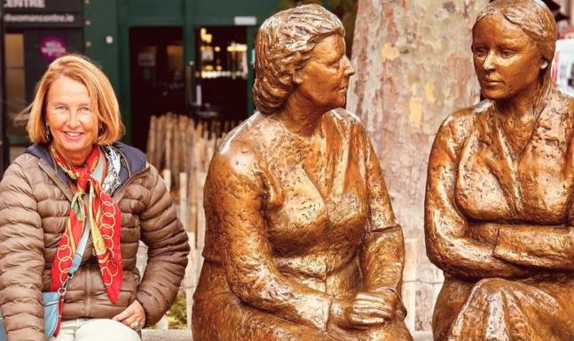 May East ao lado da escultura de bronze Meeting Place, em Dublin, na Irlanda